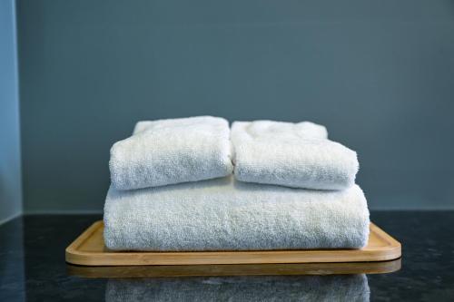 a stack of towels sitting on a wooden plate at OOD Hotel Taipei HangZhou in Taipei