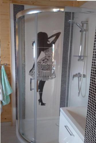 a bathroom with a shower with a woman on the wall at Domki Pod Biegunem, Strefa Relaksu, Bajkowy Świat Smerfów in Żywiec