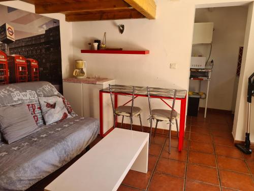 une chambre avec un canapé et deux tabourets dans une cuisine dans l'établissement STUDIO INDEPENDANT AUBAGNE proche AIX CASSIS LA CIOTAT MARSEILLE, à Aubagne