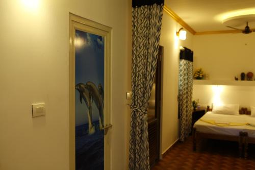 Habitación con cama y puerta a un dormitorio en Marari Neena Beach homestay, en Mararikulam