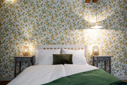 a bedroom with a bed and two night stands with lamps at Vendégház a Tábornokhoz in Visegrád