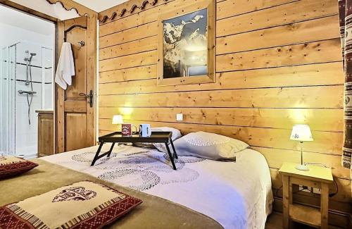 - une chambre avec un lit et un mur en bois dans l'établissement Résidence Ecrin Des Neiges A - Beau 4 pièces esprit montagne à Val Claret MAE-6874, à Tignes