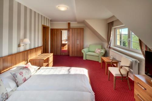 une chambre d'hôtel avec un lit et une chaise dans l'établissement Hotel Kolonie, à Křivoklát