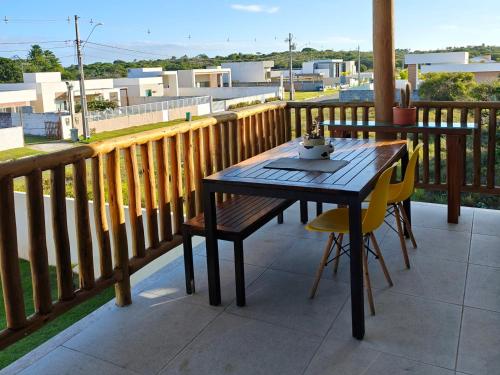 a wooden table and chairs on a balcony at Novo Village in Camaçari
