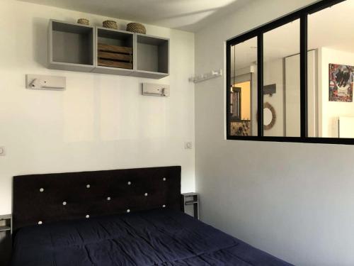 - une chambre avec un lit noir et un miroir dans l'établissement Résidence Morel - Le Morel 11 - Joli 2 pièces avec vue sur la piste de Planchamp MAE-0584, à Valmorel