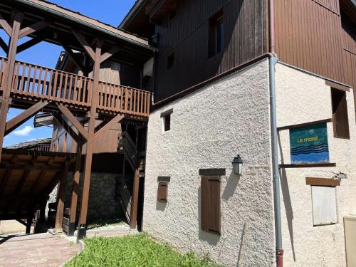 - un bâtiment avec une terrasse en bois sur le côté dans l'établissement Résidence Morel - Le Morel 11 - Joli 2 pièces avec vue sur la piste de Planchamp MAE-0584, à Valmorel