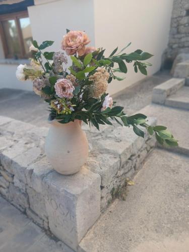 a white vase with a bouquet of flowers in it at Il Carosello dei Baroni in Noto