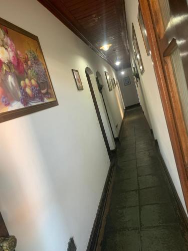 a hallway in a building with a painting on the wall at Solar Colonial Pousada in Iguape
