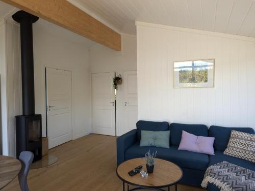 a living room with a blue couch and a table at Bjønntjønn 229 in Heimdal