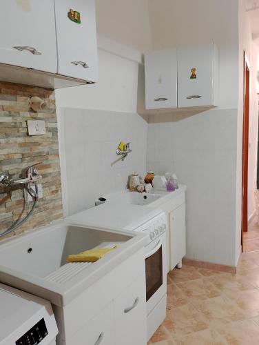 a white kitchen with a sink and a stove at Monolocale Portanuova in Pietragalla