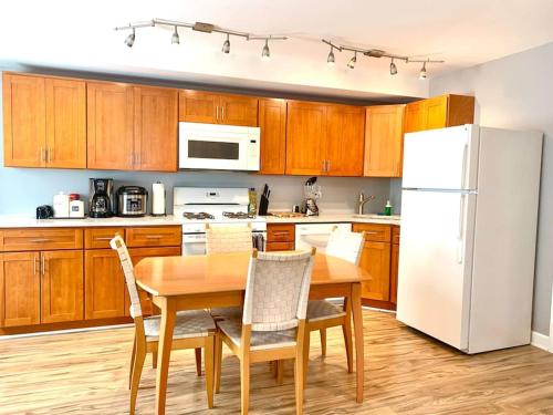 a kitchen with a table and a white refrigerator at Bridgeport Place - free parking, McCormick Place-Sox Park in Chicago