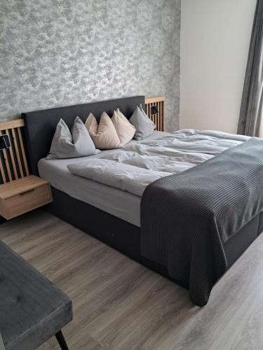 a bedroom with a large bed and a chair at Apartmenthaus Hinterer in Bad Goisern