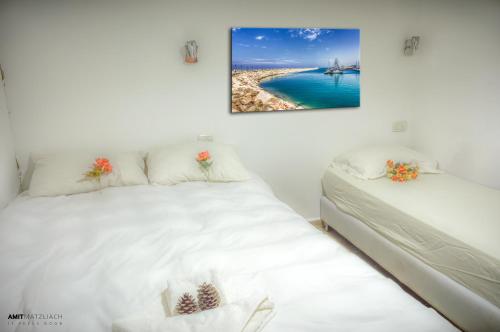 a room with two beds and a painting on the wall at Etzel Tami Hospitality in Neot Golan