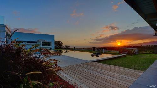 a sunset over a backyard with a wooden deck at La Villa Phoenix in Saint-Pierre