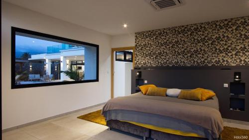 a bedroom with a bed and a large window at La Villa Phoenix in Saint-Pierre