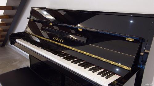 a black piano sitting next to a wall at La Villa Phoenix in Saint-Pierre