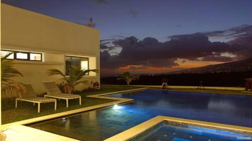 a swimming pool in front of a house at La Villa Phoenix in Saint-Pierre