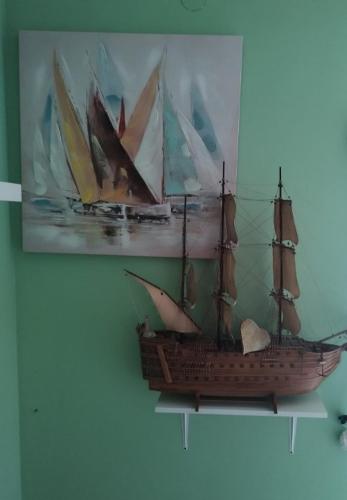 a painting of a boat hanging on a wall at Studio apartman Karmen in Varaždin Breg