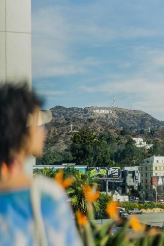 a person looking out of a window at a mountain at Loews Hollywood Hotel in Los Angeles