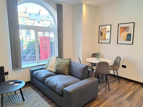 a living room with a couch and a table at Modern Bright 3 Bedroom Apartment In Converted Brewery With Secure Undercover Gated Parking in Hull