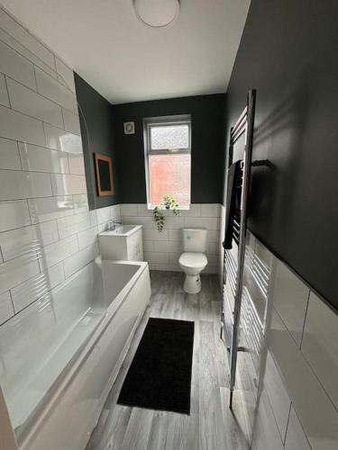 a bathroom with a tub and a toilet and a sink at 2 Bed Flat Wallsend in Willington Quay