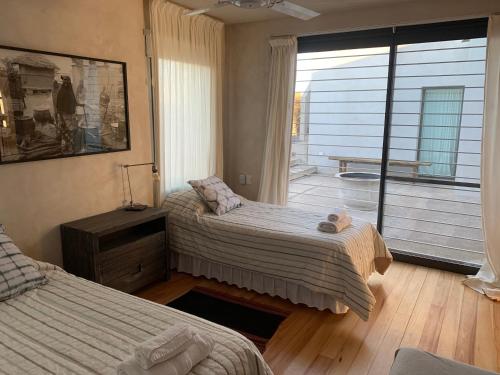 una camera da letto con due letti e un balcone di Casa del sol a Villa Allende