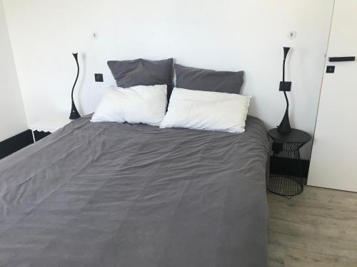 un lit avec deux oreillers dessus dans une chambre dans l'établissement maison 3 chambres proche ile de Ré, centre ville, à Puilboreau