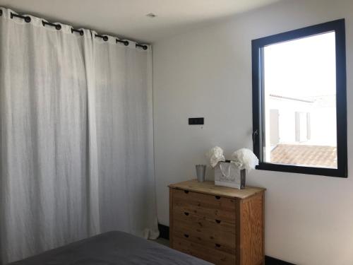 - une chambre avec un lit, une fenêtre et une commode dans l'établissement maison 3 chambres proche ile de Ré, centre ville, à Puilboreau