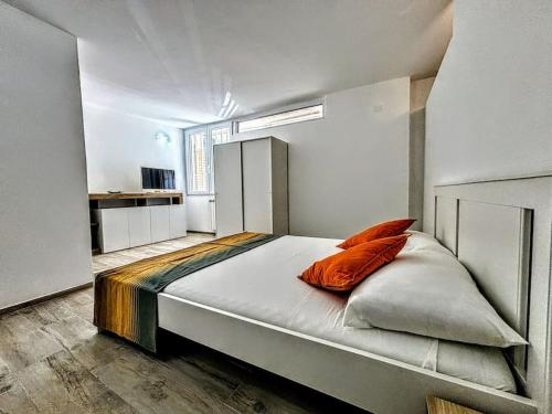 - une chambre dotée d'un lit avec des oreillers orange dans l'établissement The Great Beach Apartment - Marina di Carrara -, à Marina di Carrara