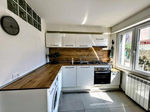 une cuisine avec des armoires blanches, un évier et une cuisinière dans l'établissement The Great Beach Apartment - Marina di Carrara -, à Marina di Carrara