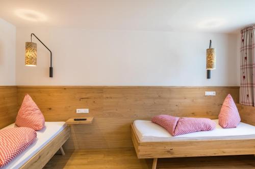 a room with two benches with pillows at Bergzeit - Hotel & Appartements in Oberjoch