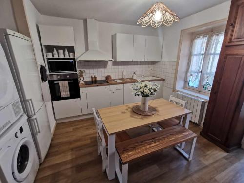 - une cuisine avec une table et des fleurs dans l'établissement Bel appartement de 1 à 7 personnes, à Ambert