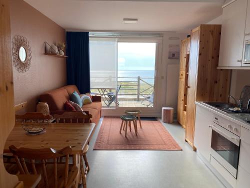 une cuisine et un salon avec un canapé et une table dans l'établissement Escapade iodée à la Naturelle Vue mer- Wifi- Wimereux Côte d'opale, à Wimereux