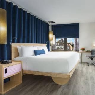 a bedroom with a large white bed and a window at Arthouse Hotel in New York