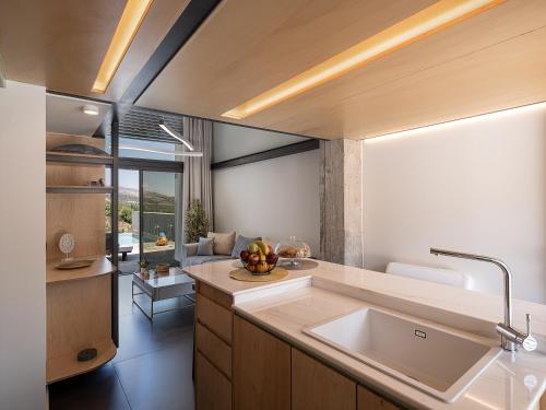 a kitchen with a sink and a living room at Nature's Den in Frangokastello