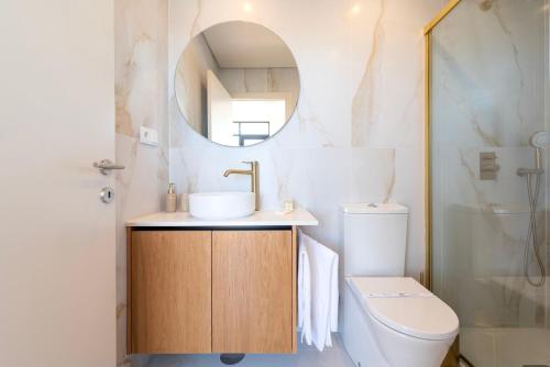 a bathroom with a sink and a toilet and a mirror at DoisPontoZero Júlio Dinis Gold in Porto