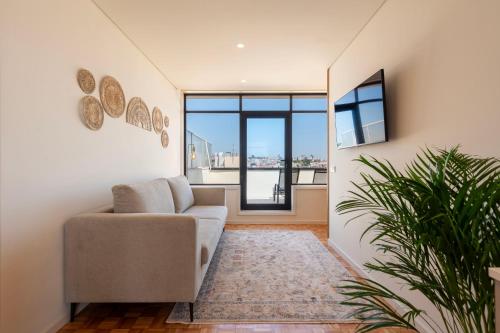 a living room with a couch and a large window at DoisPontoZero Júlio Dinis Gold in Porto