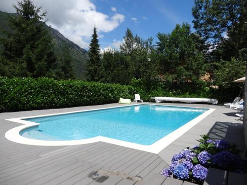 - une piscine dans une cour avec une terrasse en bois dans l'établissement Le 103. Chalet 3 chambres. Terrasse. Parking. wifi., à Cauterets