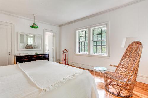 a white bedroom with a bed and a chair at Hudson Valley Estate on 4 Acres with Private Pool! in Nyack