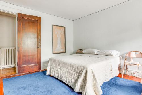 a bedroom with a white bed and a blue rug at Hudson Valley Estate on 4 Acres with Private Pool! in Nyack