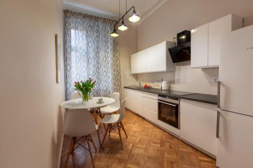 a kitchen with a table and chairs and a refrigerator at Evita 3 in Gniezno