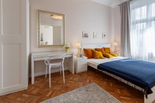 a bedroom with a bed and a desk and a mirror at Evita 3 in Gniezno