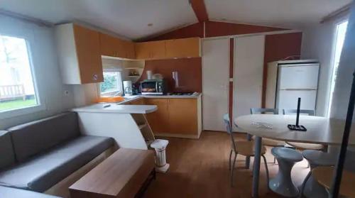 a small kitchen with a couch and a table at Mobil home 2ch 5pers Tout Confort 25min PuyduFOU 710EM in La Boissière-de-Montaigu