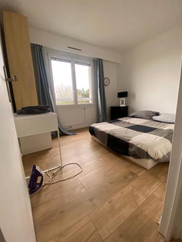 une chambre avec un lit et une grande fenêtre dans l'établissement Paris grand et belle appartement banlieue, à LʼHay-les-Roses