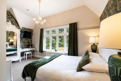 a bedroom with a large bed and a window at Roomours Hotel with Private Car Park in Llandudno