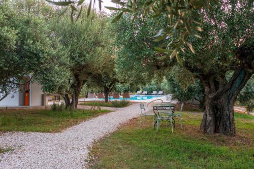 a table and chairs in a park with trees at Armandiola in Cardedu