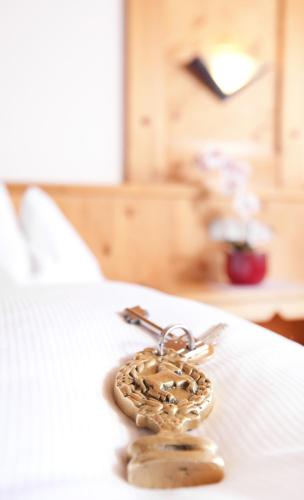 a heart shaped keychain sitting on top of a bed at Appartementhaus zum Holzknecht am See in Neustift im Stubaital