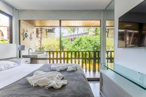 ein Schlafzimmer mit einem Bett mit zwei Handtüchern darauf in der Unterkunft Nannai Residence Muro Alto Porto de Galinhas por Brevelar in Porto De Galinhas