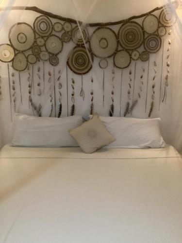 a bed with a bunch of clocks on the wall at Yaxchen Tulum Cabañas & Cenote in Tulum