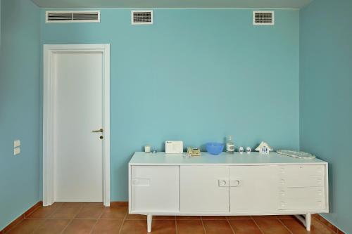 a room with a white cabinet and a blue wall at soft blue apartment near seaside in Porto Rafti